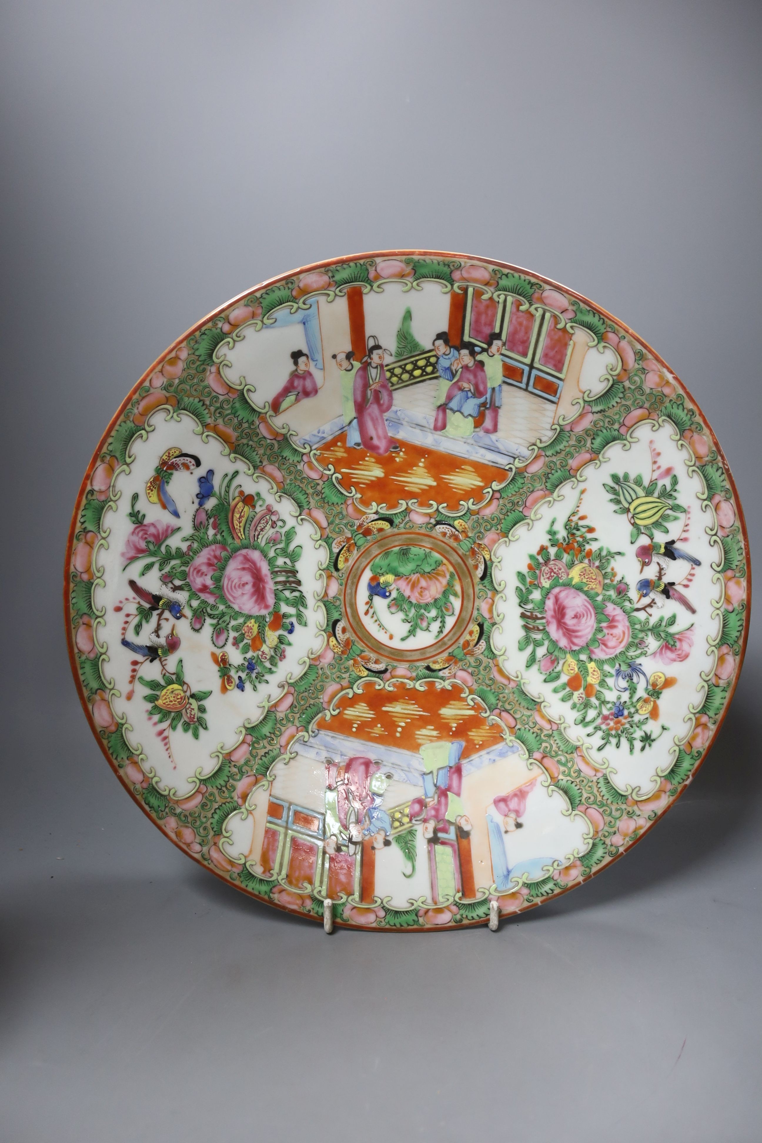 Three late 19th/early 20th century Chinese famille teapots, two in baskets and a similar dish, dish 29.5 cms diameter.